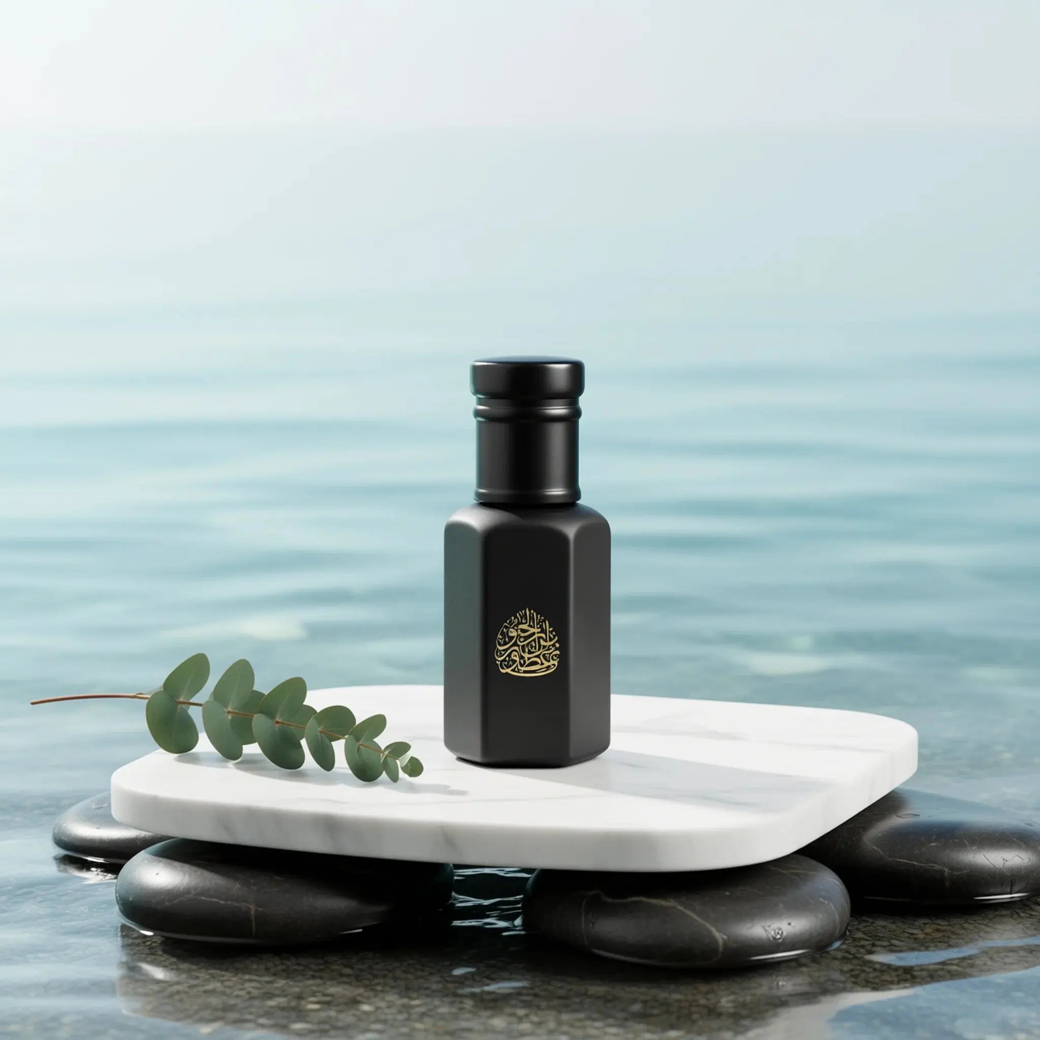 Black glass fragrance bottle with gold logo, placed on smooth stones by water, featuring an elegant minimalist design.